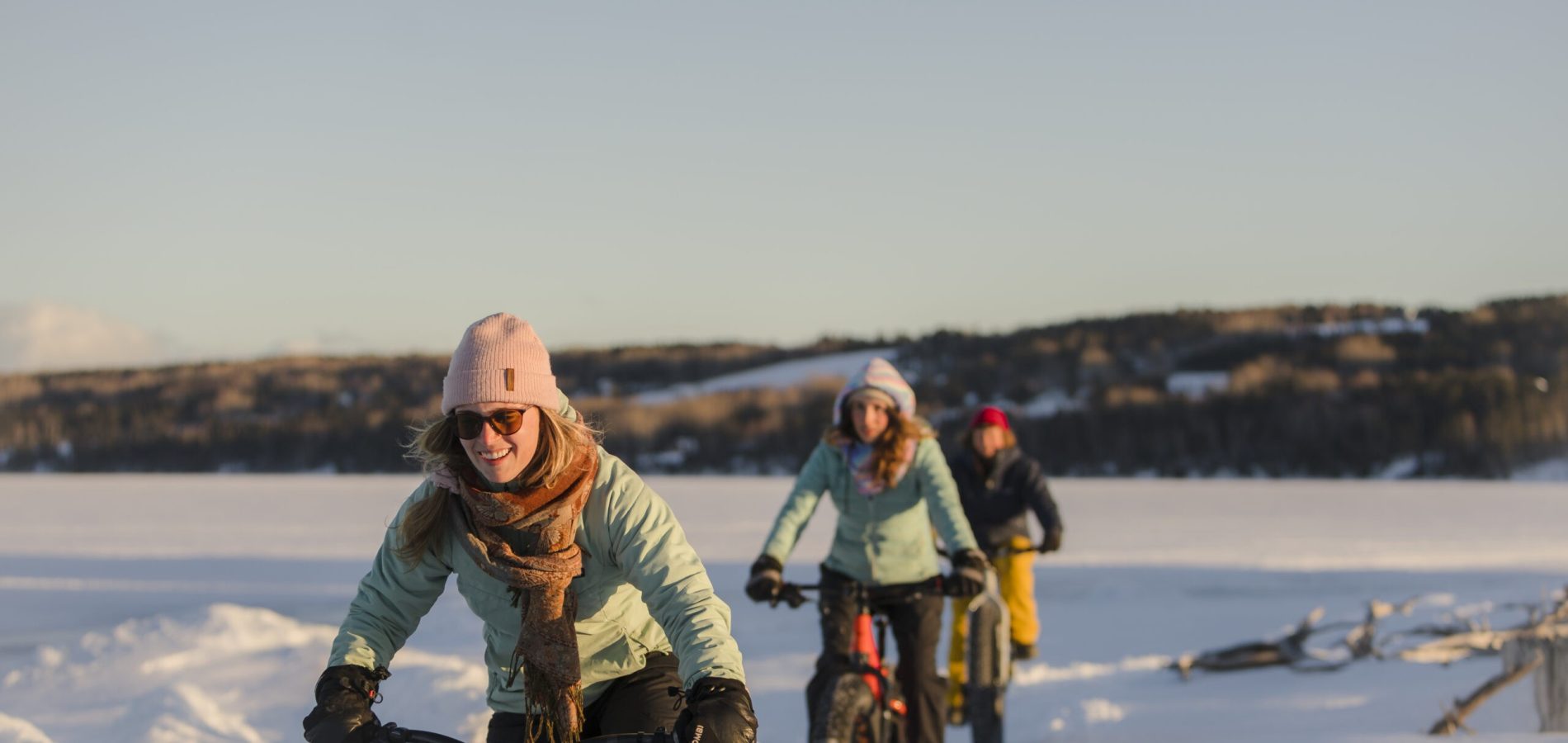 Un groupe de fille en vélo en hiver aux Chalets du bout du monde dans les sentiers tracés.