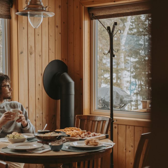 Un homme qui prend son petit-déjeuner dans un chalet à Gaspé.