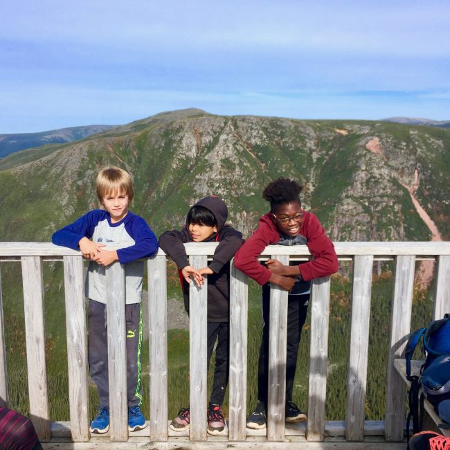 Trois enfants avec la vue de la montagne en arrière-plan.
