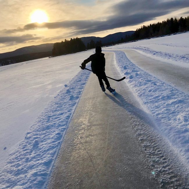 Un jeune patineur avec bâton de hockey sur la glace.