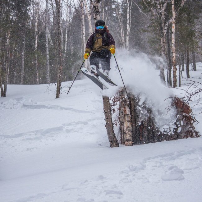 Un homme vêtu d'un habit de neige descendant une montagne en ski.